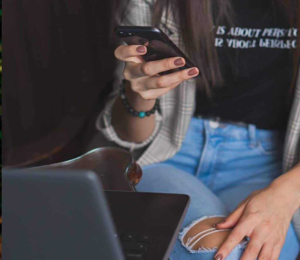 Person on their phone and laptop